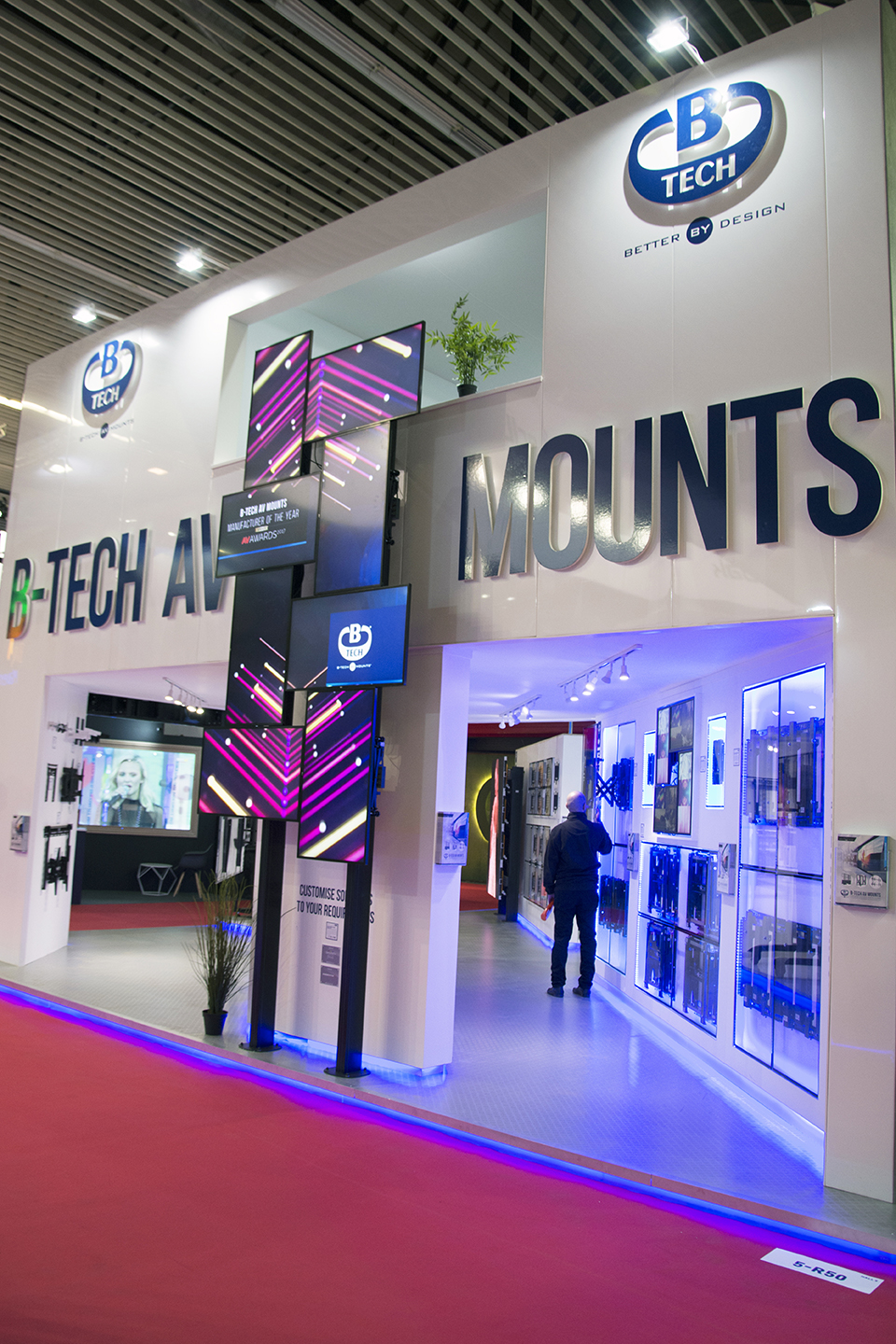 View of the B-Tech AV Mounts stand entrance featuring illuminated branding and AV mounting displays.