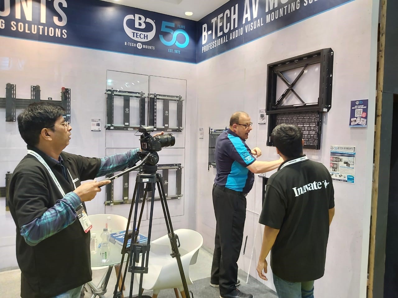 An image of Jon Alway Demonstrating a flat screen wall mount with integrated Pull out AV Storage tray to InAVate.