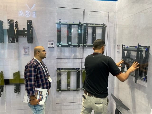 An Image of two men testing B-Techs range of Pop-out wall mounts