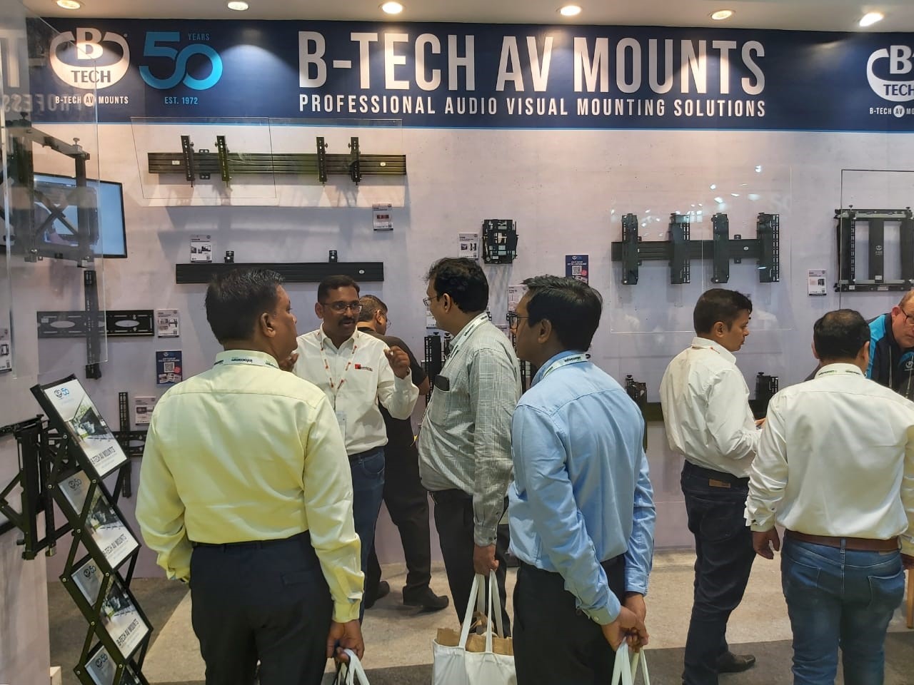 An image of multiple men browsing our range of system X products and pop-out wall mounts